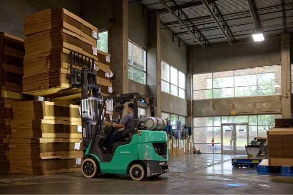 Forklift worker moving corrugate packaging in a warehouse