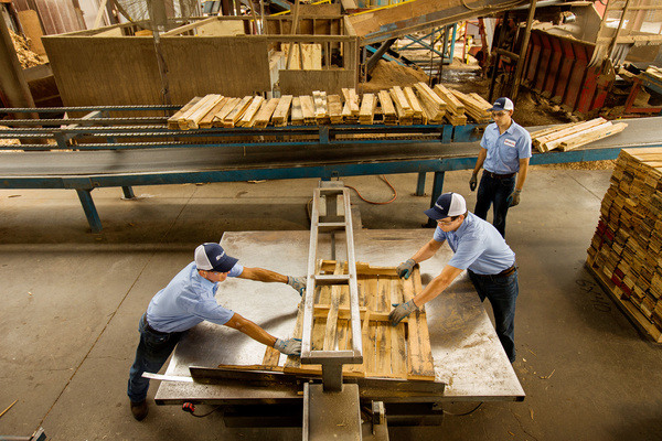 PalletOne employees working to restore a recycled pallet